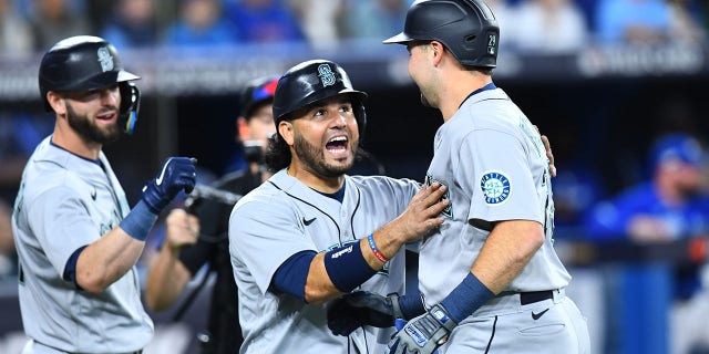 Seattle Mariners catcher Cal Raleigh, right, celebrates his home run with infielder Eugenio Suarez during the first inning of wild-card Game 1 against the Toronto Blue Jays Oct. 7, 2022, in Toronto.