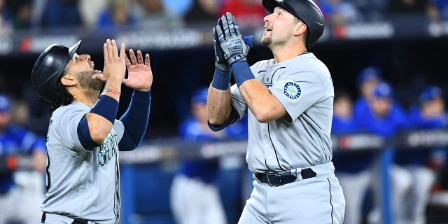 Seattle Mariners catcher Cal Raleigh, right, celebrates a home run with infielder Eugenio Suarez during the first inning of wild-card Game 1 against the Toronto Blue Jays Oct. 7, 2022, at Rogers Centre in Toronto.