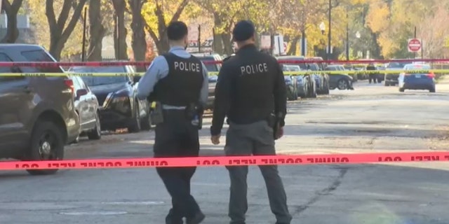 Officers are pictured investigating a shooting on the Southwest Side on Saturday. Police said five people were murdered over the weekend.