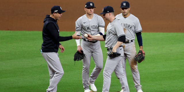 Aaron Boone #17 of the New York Yankees knocks Clark Schmidt #86 out of the game during the sixth inning against the Houston Astros at Minute Maid Park on October 19, 2022 in Houston, Texas.