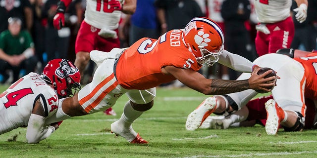 Clemson quarterback DJ Uiagalelei (5) scores a touchdown while being brought down by North Carolina State cornerback Derrek Pitts Jr.  (24) in the first half of an NCAA college football game, Saturday, Oct. 1, 2022, in Clemson, SC. 