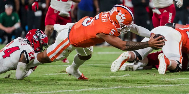 Clemson quarterback DJ Uiagalelei (5) scores a touchdown while being brought down by North Carolina State cornerback Derrek Pitts Jr. (24) in the first half of an NCAA college football game, Saturday, Oct. 1, 2022, in Clemson, S.C. 