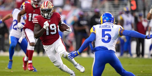 Wide receiver Deebo Samuel #19 of the San Francisco 49ers rushes for a touchdown as he breaks a tackle by cornerback Jalen Ramsey #5 of the Los Angeles Rams during the second quarter at Levi's Stadium on Oct. 3, 2022 in Santa Clara, California.