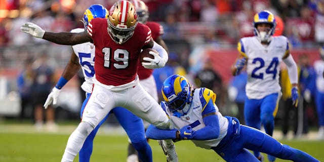 Wide receiver Deebo Samuel #19 of the San Francisco 49ers rushes for a touchdown as he breaks a tackle by cornerback Jalen Ramsey #5 of the Los Angeles Rams during the second quarter at Levi's Stadium on October 03, 2022 in Santa Clara, California.