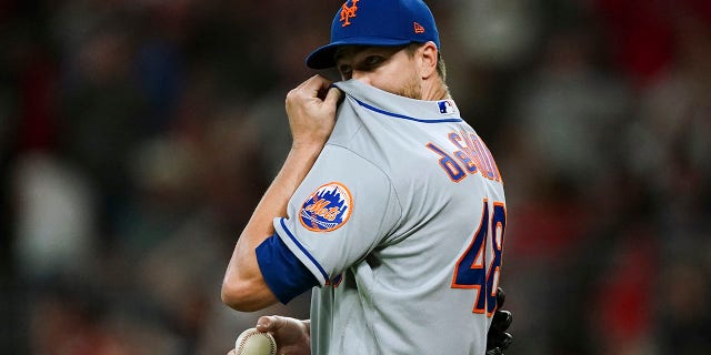 New York Mets starting pitcher Jacob deGrom wipes his face after allowing a solo home run to Atlanta Braves' Matt Olson during the second inning of a baseball game Friday, Sept. 30, 2022, in Atlanta.