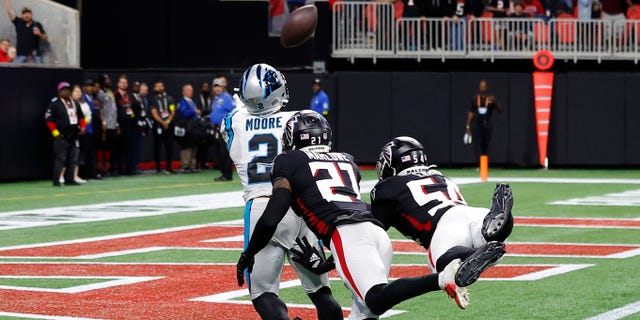 DJ Moore nº 2 do Carolina Panthers recebe um passe para touchdown contra Dean Marlowe nº 21 do Atlanta Falcons e Rashaan Evans nº 54 do Atlanta Falcons durante o quarto período no Mercedes-Benz Stadium em 30 de outubro de 2022 em Atlanta, Geórgia.