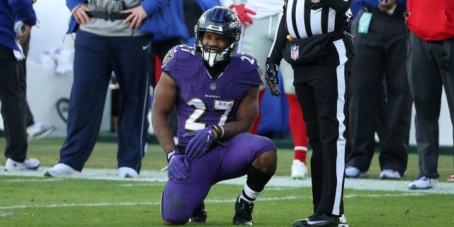 Running back J.K. Dobbins #27 of the Baltimore Ravens reacts after being hit by linebacker Cameron Brown #47 of the New York Giants during the third quarter at M&T Bank Stadium on Dec. 27, 2020, in Baltimore, Maryland.