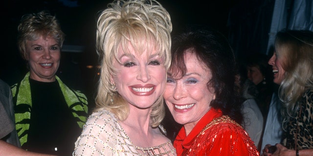 American singer-songwriter Dolly Parton poses with American country singer Loretta Lynn circa 1997 at the Grand Ole Opry in Nashville, Tennessee. 