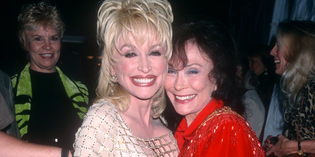 American singer-songwriter Dolly Parton poses with American country singer Loretta Lynn circa 1997 at the Grand Ole Opry in Nashville, Tennessee. 