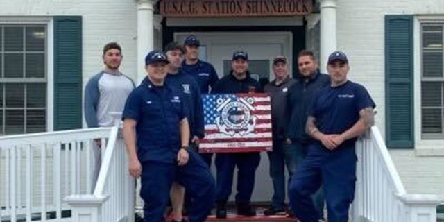 TJ Foley (far right) stands in front of fellow USCG reserve member and friend Drew Vukov - who helped start Foley's fundraising page.