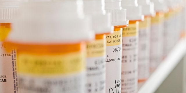 Bottles of pills arranged on shelf in a pharmacy