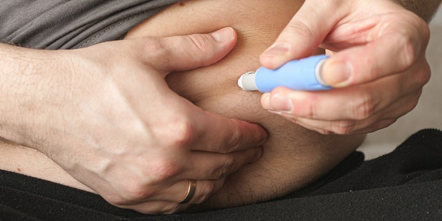 A man clings to an injection of Semaglutide Ozempic, a type 2 diabetes drug that is now also used for weight loss.