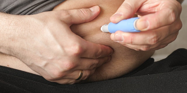 Man sticking himself with the Semaglutide Ozempic injection, a treatment for Type 2 Diabetes that is now also being used for weight loss.