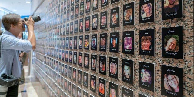 A photojournalist takes a picture of a wall memorializing Americans killed by fentanyl intake.