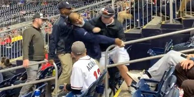 Washington DC firefighter Christopher Sullivan, who is on administrative leave, is seen punching an usher at Nationals Park in the face while being escorted out of the park.