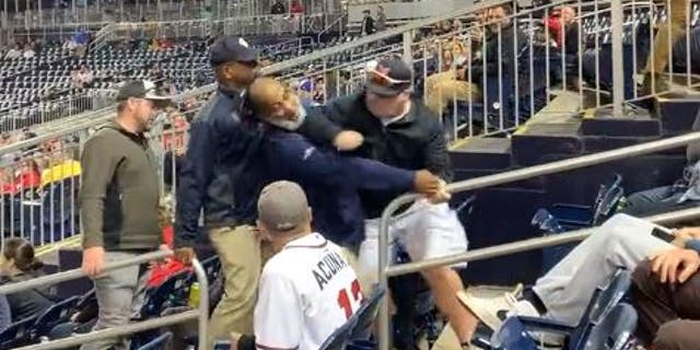 Washington DC firefighter Christopher Sullivan, who is on administrative leave, is seen punching an usher at Nationals Park in the face while being escorted out of the park.