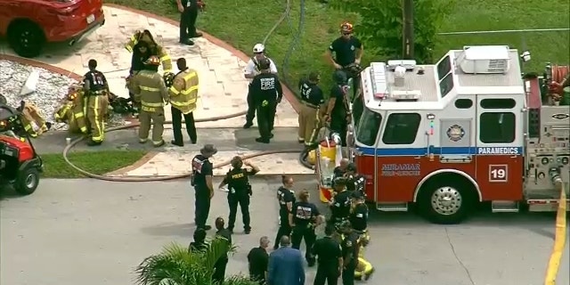 Miramar fire personnel seen outside a home struck by a small plane.