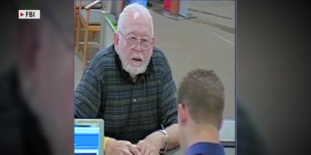 Donald Griffith, who had $750,000 stolen from him in a romance scam, deposits money at a bank teller.