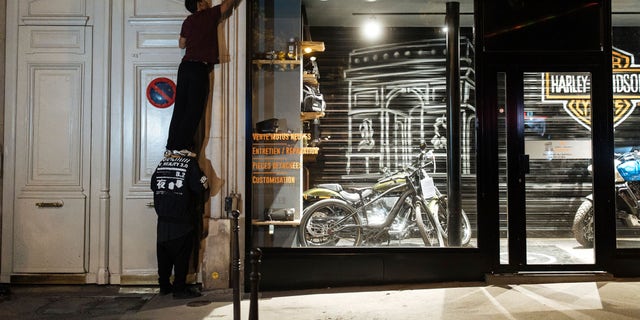 The "On the Spot" collective in France turns off lights at a Paris storefront during a night of action on July 29, 2022, in an effort to save energy ahead of a possible energy crisis in Europe.