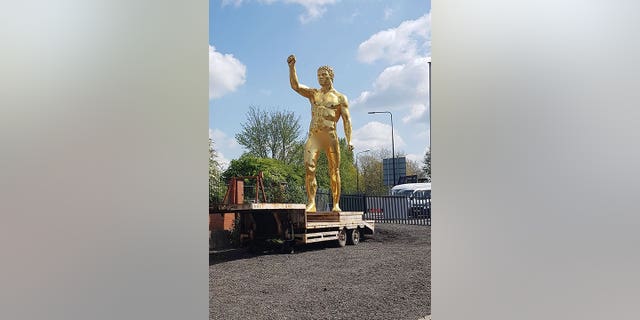 A business owner has slammed the council after he was ordered to remove a 30-foot gold nude statue from outside his shop – after a man reportedly complained it was "obscene."