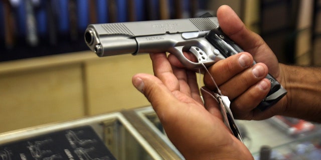 A man chooses a gun April 18, 2007, at the Gun Gallery in Glendale, California.