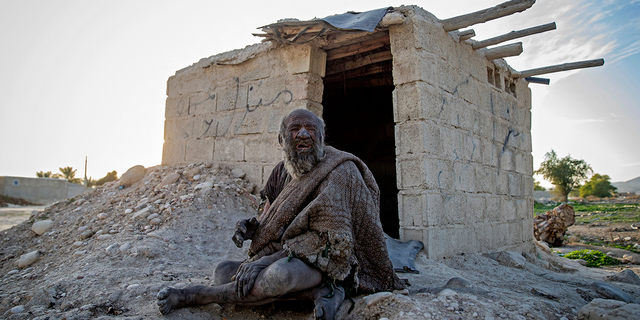 Amou Haji (uncle Haji) sits in front of an open brick shack that the villagers constructed for him, on the outskirts of the village of Dezhgah in the Dehram district of the southwestern Iranian Fars province, on December 28, 2018. - Believed to be the worlds dirtiest man, villagers say that Haji's leather-like skin hasn't touched soap and water for more than sixty years. They believe that he decided to live in isolation after suffering from an emotional setback in his youth. (Photo by - / AFP) (Photo by -/AFP via Getty Images)