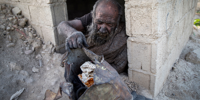 Amou Haji (uncle Haji) sits at the entrance of an open brick shack that the villagers constructed for him, on the outskirts of the village of Dezhgah in the Dehram district of the southwestern Iranian Fars province, on December 28, 2018. - Believed to be the worlds dirtiest man, villagers say that Haji's leather-like skin hasn't touched soap and water for more than sixty years. They believe that he decided to live in isolation after suffering from an emotional setback in his youth. (Photo by - / AFP) (Photo by -/AFP via Getty Images)