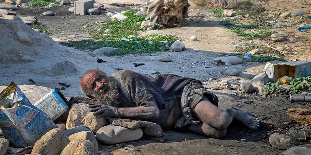 Amou Haji (uncle Haji) lies on the ground on the outskirts of the village of Dezhgah in the Dehram district of the southwestern Iranian Fars province, on December 28, 2018. - Believed to be the worlds dirtiest man, villagers say that Haji's leather-like skin hasn't touched soap and water for more than sixty years. They believe that he decided to live in isolation after suffering from an emotional setback in his youth. (Photo by - / AFP) (Photo by -/AFP via Getty Images)