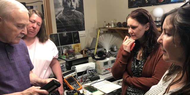 PI-NE team members are shown in a lab working on one of their cases.