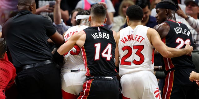 Tyler Herro #14 of the Miami Heat and Fred VanVleet #23 of the Toronto Raptors help pull away teammates after Caleb Martin #16 of the Miami Heat and Christian Koloko #35 of the Toronto Raptors get into an altercation during the third quarter at FTX Arena on October 22, 2022 in Miami, Florida.