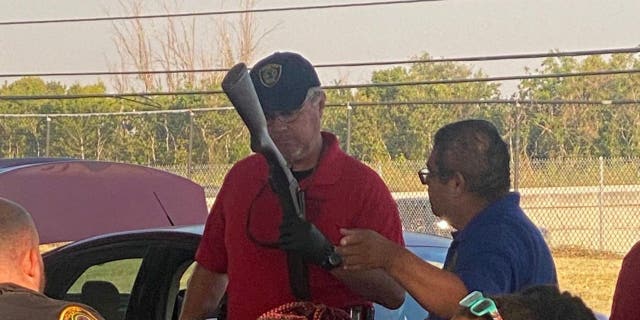 A police officer looks over a gun turned in during a buyback event in Houston, Texas on Oct. 8, 2022.