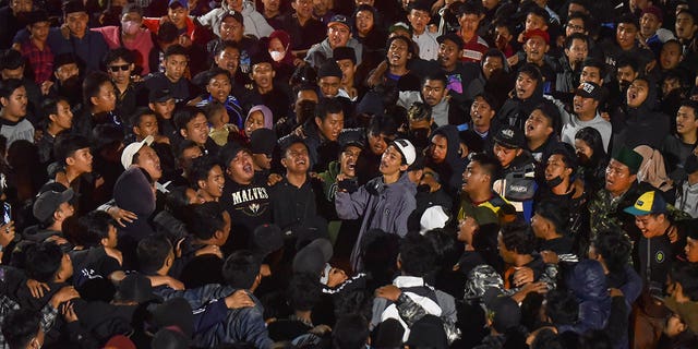 Soccer fans chant slogans during vigil for the victims of Saturday's deadly crush, in Malang, East Java, Indonesia, Sunday, Oct. 2, 2022. Panic at an Indonesian soccer match Saturday left over 100 people dead, most of whom were trampled to death after police fired tear gas to prevent violence. 