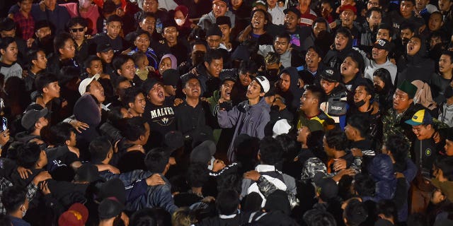 Soccer fans chant slogans during vigil for the victims of Saturday's deadly crush, in Malang, East Java, Indonesia, on Sunday.