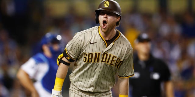 Jake Cronenworth #9 of the San Diego Padres celebrates his single home run in the eighth inning during game two of the National League Division Series against the Los Angeles Dodgers at Dodger Stadium on October 12, 2022 in Los Angeles, California.