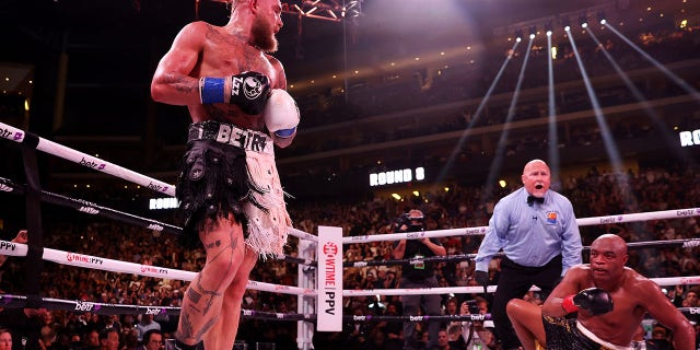 Jake Paul (L) reacts after knocking down Anderson Silva of Brazil during their cruiserweight bout at Gila River Arena on October 29, 2022 in Glendale, Arizona.