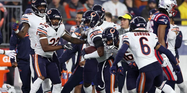 #9 Yakuan Brisker of the Chicago Bears celebrates with teammates after a second-quarter pass interception against the New England Patriots at Gillette Stadium on October 24, 2022 in Foxborough, Massachusetts.
