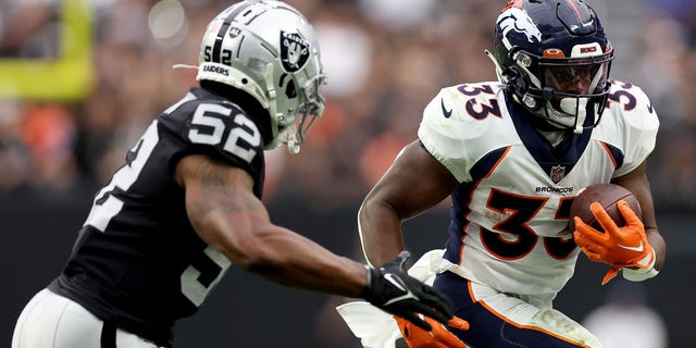 Javonte Williams #33 of the Denver Broncos runs with the ball while being chased by Denzel Perryman #52 of the Las Vegas Raiders in the second quarter at Allegiant Stadium on Oct. 2, 2022 in Las Vegas, Nevada.