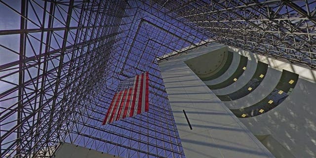 A photo inside the John F. Kennedy Library and Museum shows a 115-foot-tall glass pavilion overlooking Dorchester Bay.