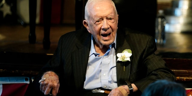 Former President Jimmy Carter reacts as his wife Rosalynn Carter speaks during a reception to celebrate their 75th wedding anniversary Saturday, July 10, 2021, in Plains, Ga.