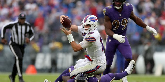 Josh Allen of the Buffalo Bills runs with the ball as Jason Pierre-Paul of the Ravens tackles him on October 2, 2022 in Baltimore.