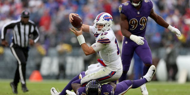 Josh Allen of the Buffalo Bills runs with the ball as Jason Pierre-Paul of the Ravens tackles him on October 2, 2022 in Baltimore.