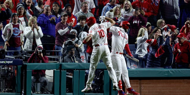   JT Realmut #10 and Bryce Harper #3 of the Philadelphia Phillies hit the Padres' seventh inning in Game 4 of the National League Championship Series at Citizens Bank Park in Philadelphia, Pennsylvania on October 22, 2022. celebrated Realmut's solo home run.