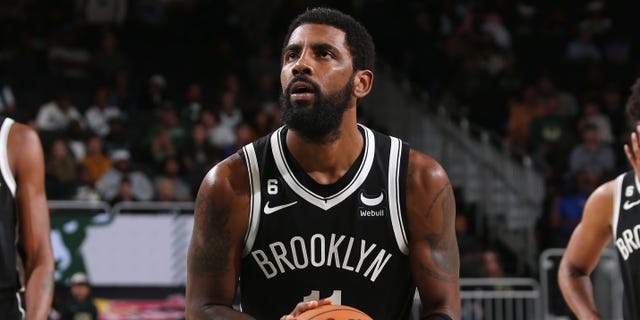 Kyrie Irving #11 of the Brooklyn Nets shoots a free throw during the game against the Milwaukee Bucks on October 12, 2022, at the Fiserv Forum Center in Milwaukee, Wisconsin.