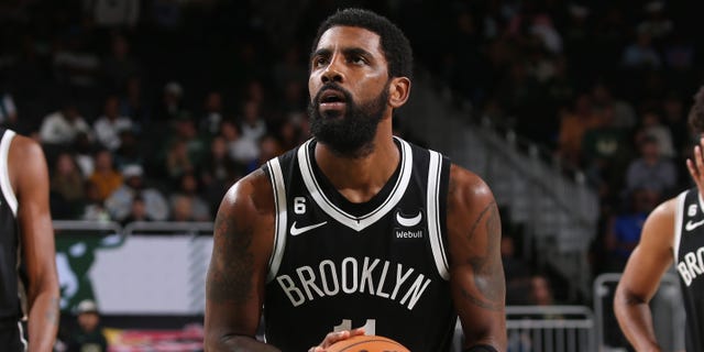 Kyrie Irving #11 of the Brooklyn Nets hits a free throw during a game against the Milwaukee Bucks at the Fiserv Forum Center in Milwaukee, Wisconsin, on October 12, 2022. 