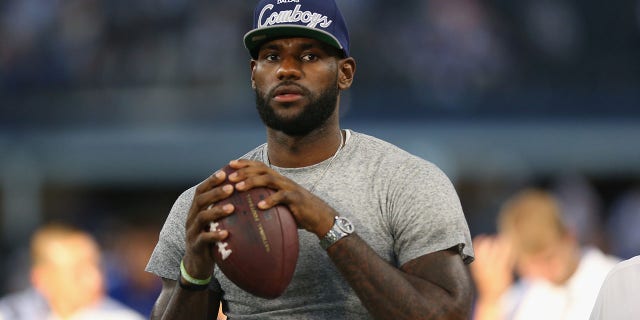Lebron James of the Miami Heat throws a football at AT and T Stadium before a game between the New York Giants and the Dallas Cowboys Sept. 8, 2013, in Arlington, Texas.