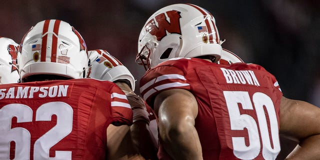 Wisconsin Badgers offensive lineman Tanor Bortolini (63), Wisconsin Badgers offensive lineman Michael Furtney (74), Wisconsin Badgers offensive lineman Kayden Lyles (54), Wisconsin Badgers offensive lineman Cormac Sampson (62), Wisconsin Badgers offensive lineman Logan Brown (50) and the rest of the Wisconsin Badger offense huddle up durning a college football game between the Eastern Michigan Eagles and the Wisconsin Badgers on September 11th, 2021 at Camp Randall Stadium in Madison, WI.