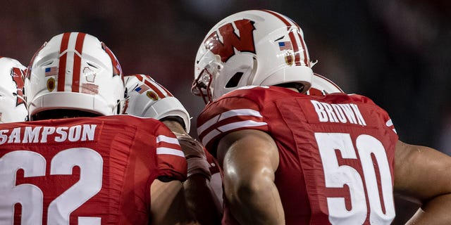 Wisconsin Badgers offensive lineman Tanor Bortolini (63), Wisconsin Badgers offensive lineman Michael Furtney (74), Wisconsin Badgers offensive lineman Kayden Lyles (54), Wisconsin Badgers offensive lineman Cormac Sampson (62), Wisconsin Badgers offensive lineman Logan Brown (50) and the rest of the Wisconsin Badger offense huddle up durning a college football game between the Eastern Michigan Eagles and the Wisconsin Badgers on September 11th, 2021 at Camp Randall Stadium in Madison, WI.