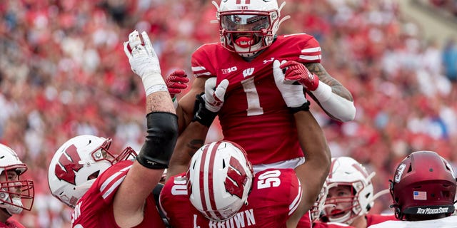 Wisconsin Badgers offensive lineman Logan Brown (50) lifts up Wisconsin Badgers running back Chez Mellusi (1) in celebration of a touchdown run durning a college football game between the New Mexico State Aggies and the Wisconsin Badgers on September 17th, 2022 at Barry Alvarez field in Camp Randall Stadium in Madison, WI.