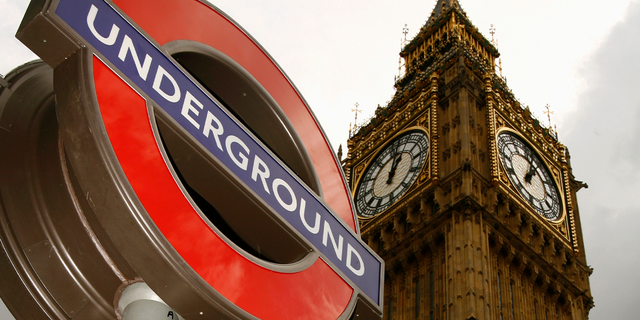 A London Underground sign is pictured below Big Ben in London.