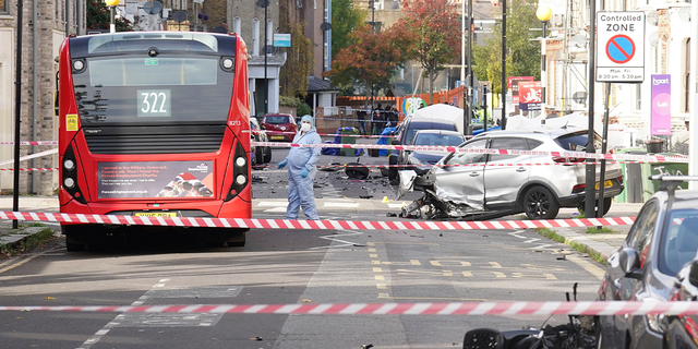Police officers in forensic suits at the scene on Railton Road in Lambeth, where two men have died after gunshots were heard on Sunday evening, in South London, Monday, Oct. 31, 2022.